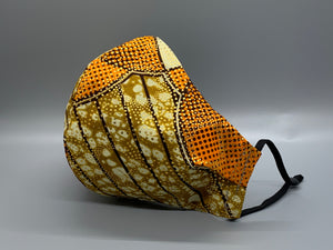 Handmade Triple Layer Cotton Facemask. Gold metallic dots atop patterns of overlapping circles & lines. Oranges, white and brown make this fabric Royal. Gray filter pocket. Fabric enclosed nose wire. Comfy adjustable black elastic earloops. Cut from one cloth-meaning fabric is same and where your pattern lies may vary. non-returnable/non-refundable. non medical grade. not a replacement for medical grade personal protective equipment (PPE), surgical masks, N95s, or social distancing. follow all recommended C