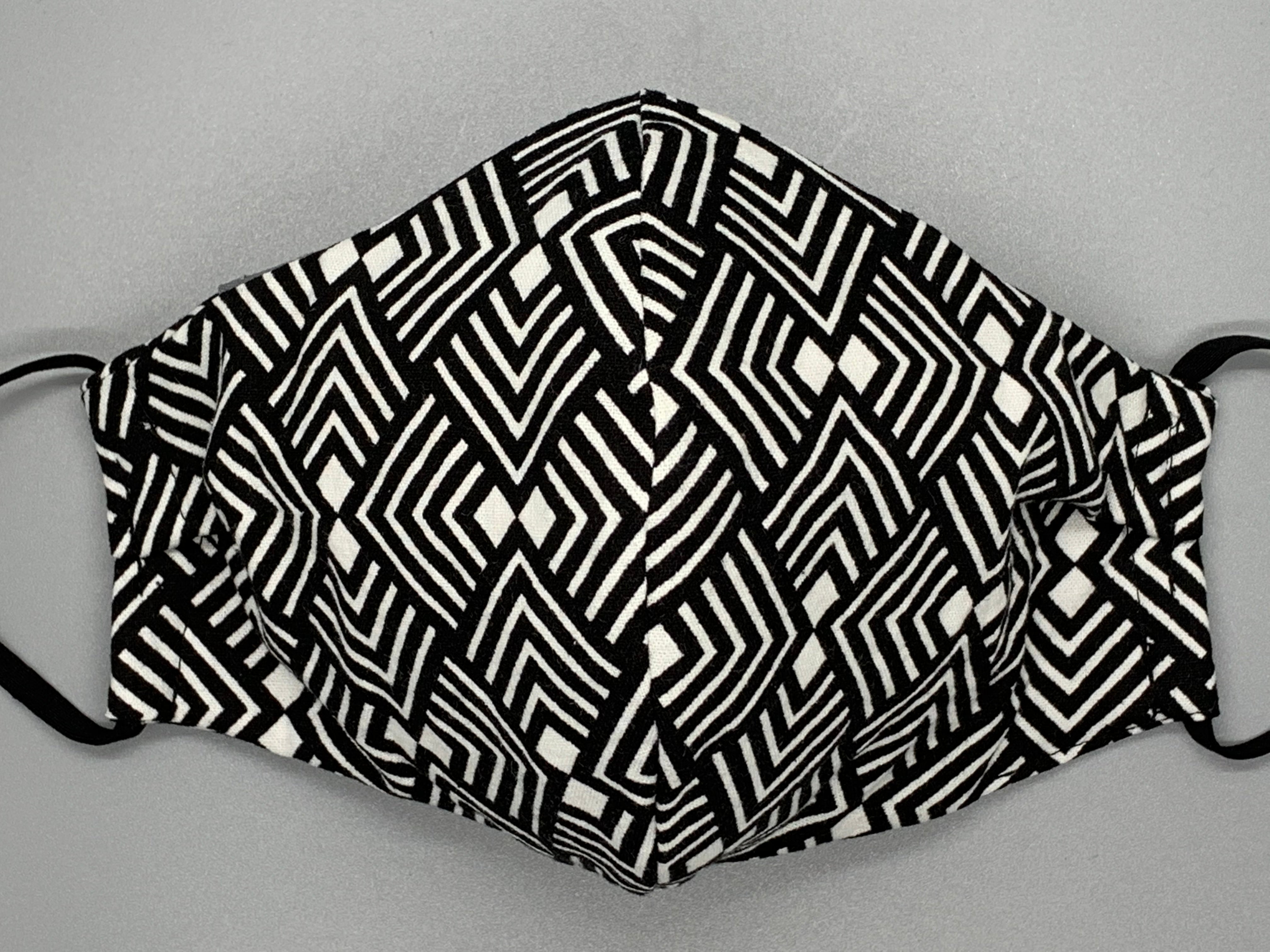  Handmade Triple Layer Cotton Facemask. Black and white lined pattern repeats on this bold fabric. Gray filter pocket. Fabric enclosed nose wire. Comfy adjustable black elastic earloops. Cut from one cloth-meaning fabric is same and where your pattern lies may vary. non-returnable/non-refundable. non medical grade. not a replacement for medical grade personal protective equipment (PPE), surgical masks, N95s, or social distancing. follow all recommended CDC guidelines.