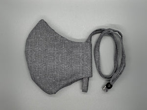 Handmade Triple Layer Cotton Facemasks. Grey & white cotton with a burlap pattern, reminds me of static :) Overhead/Back of Head cotton loop from same fabric. Adjustable Wood Bead for perfect fit. This mask has no nose wire-the adjustable overhead loop gives you a snug fit. Cut from one cloth-meaning fabric is same and where your pattern lies may vary. non-returnable/non-refundable. non medical grade. not a replacement for medical grade personal protective equipment (PPE), surgical masks, N95s, or social di