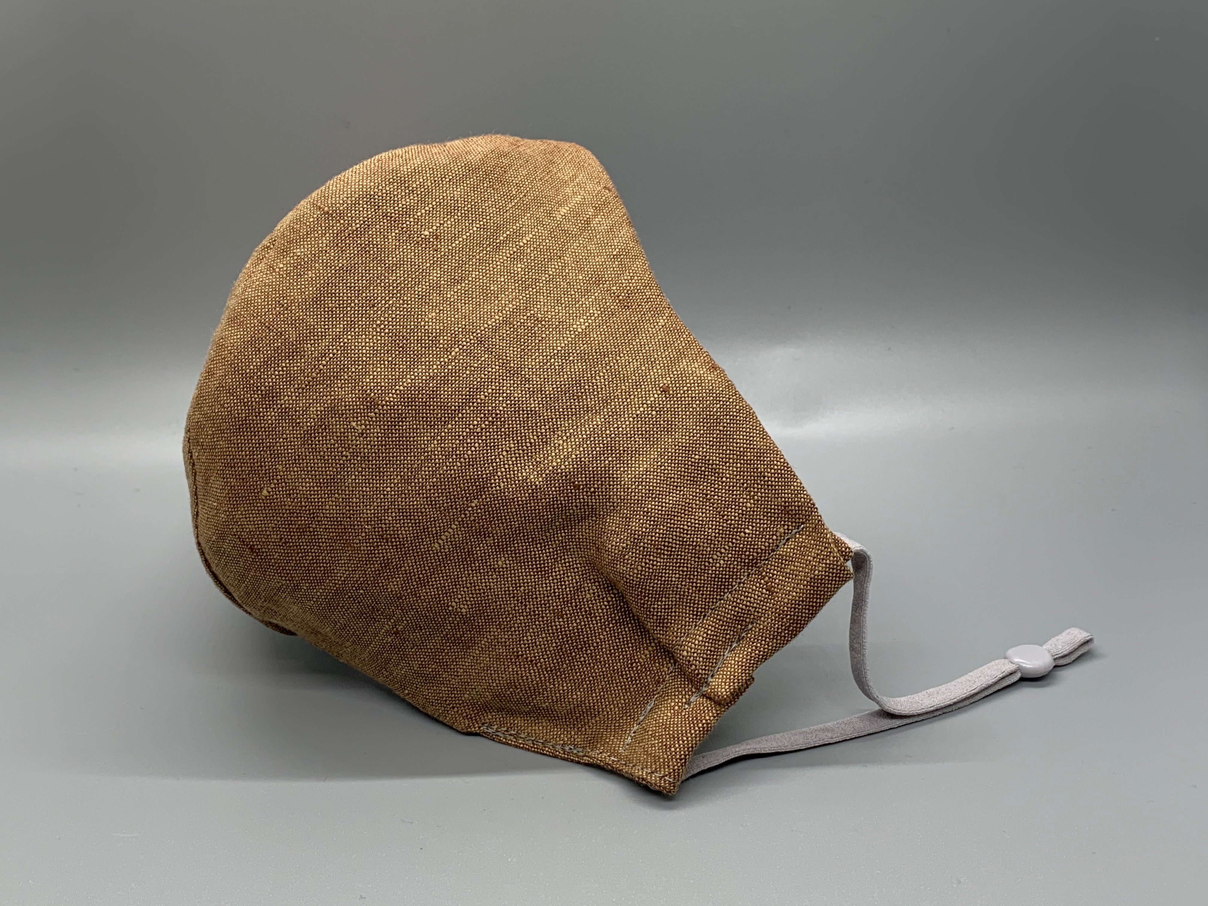 Light brown linen with that perfect wrinkle. Gray filter pocket. Fabric enclosed nose wire. Comfy adjustable gray earloops.  Cut from one cloth-meaning fabric is same and where your pattern lies may vary. non-returnable/non-refundable. non medical grade. not a replacement for medical grade personal protective equipment (PPE), surgical masks, N95s, or social distancing. follow all recommended CDC guidelines.