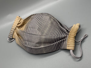 Tan and brown ombre beneath thin white stripes. Fabric enclosed nose wire. Comfy adjustable gray elastic earloops. This mask has no filter pocket. It still has 3 layers of cotton plus one layer non woven interfacing.   Cut from one cloth-meaning fabric is same and where your pattern lies may vary. non-returnable/non-refundable. non medical grade. not a replacement for medical grade personal protective equipment (PPE), surgical masks, N95s, or social distancing. Follow all recommended CDC guidelines.