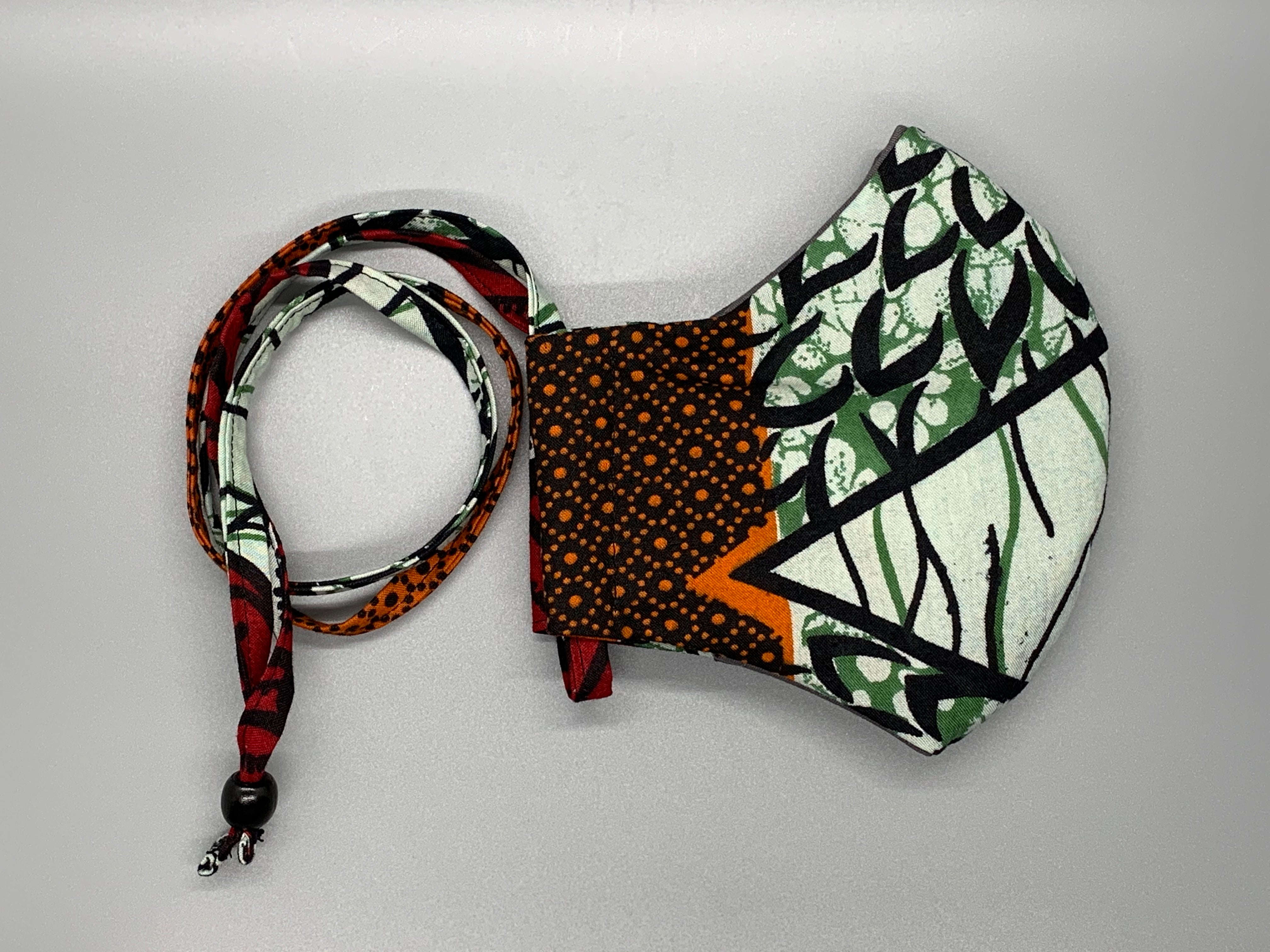 Cool green and black vine with orange, foam, green, and red pattern. Gray filter pocket. Overhead/Back of Head cotton loop from same fabric. Adjustable Wood Bead for perfect fit. This mask has no nose wire-the adjustable overhead loop gives you a snug fit.  Cut from one cloth-meaning fabric is same and where your pattern lies may vary. non-returnable/non-refundable. non medical grade. 