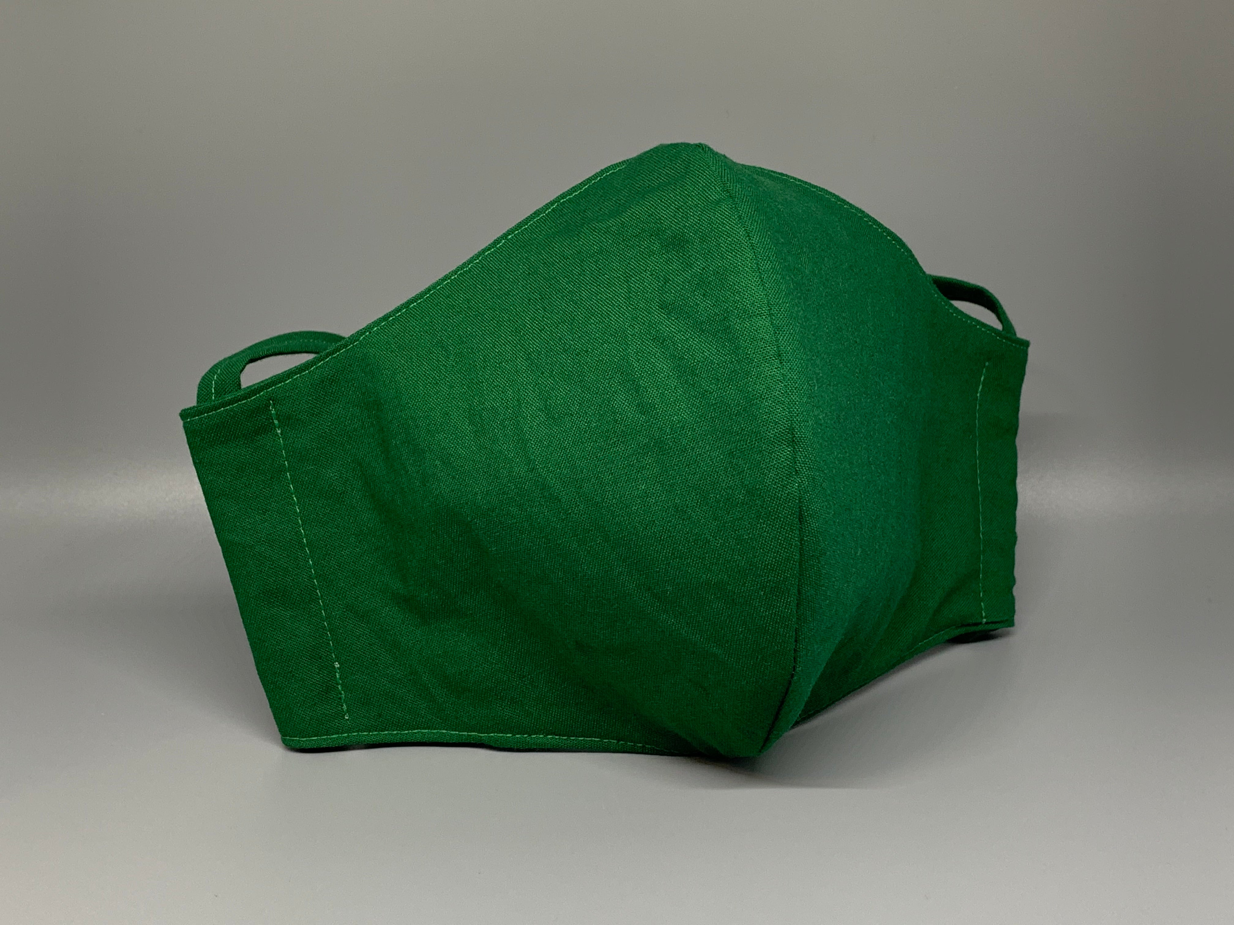 Vibrant solid green cotton. Gray filter pocket. Overhead/Back of Head cotton loop from same fabric. Adjustable Wood Bead for perfect fit. This mask has no nose wire-the adjustable overhead loop gives you a snug fit.