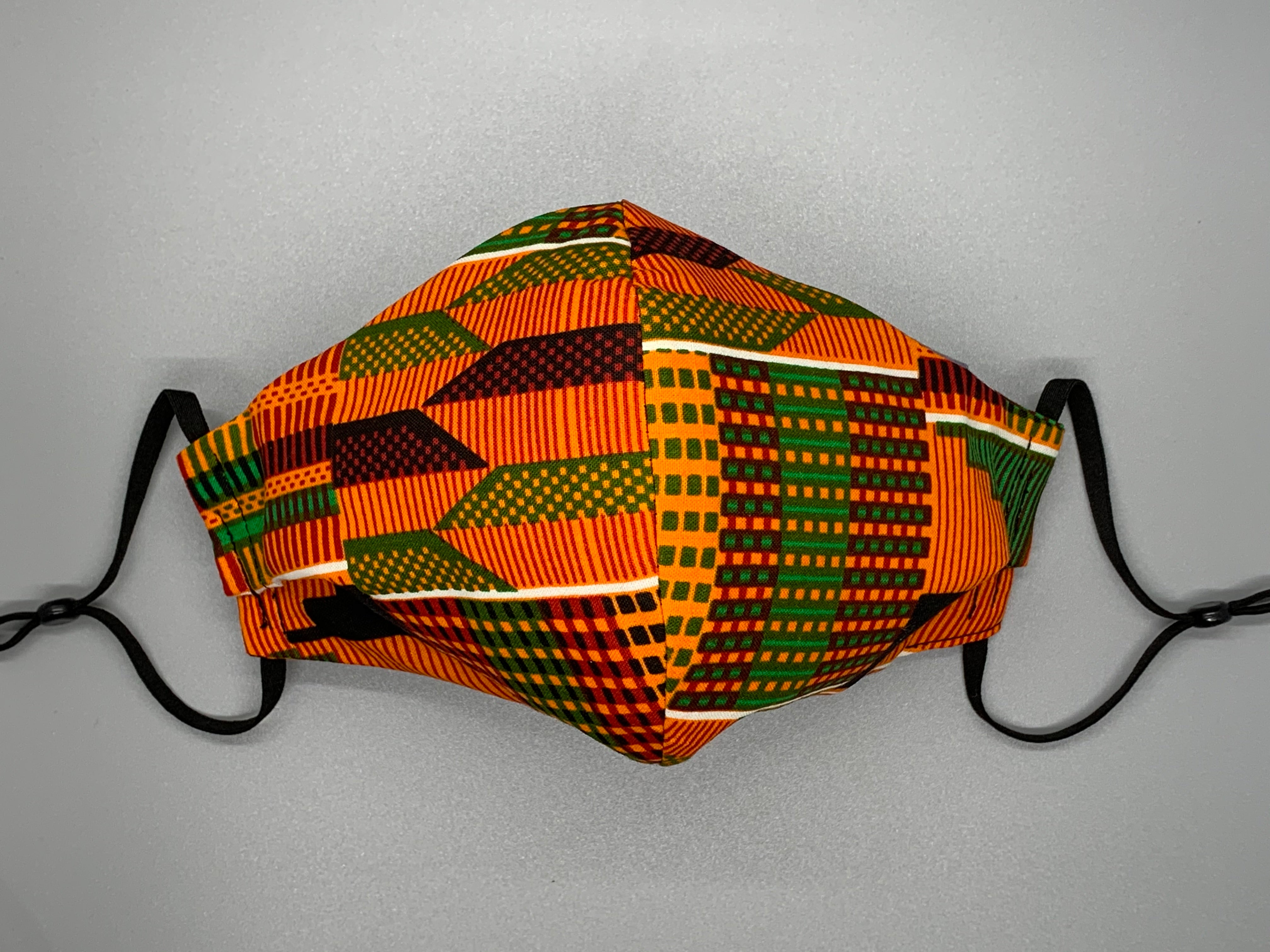 Handmade triple layer cotton facemask. Kente Inspired cotton. Vibrant patterns on orange background. Fabric enclosed nose wire. Grey filter pocket. Comfy adjustable black elastic ear loops.  Edit alt text