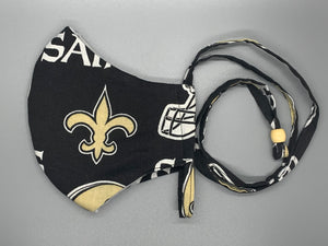 Handmade triple layer cotton facemask. Saints Fans, get your gear! Black filter pocket. Overhead/Back of Head cotton loop from same fabric. Adjustable Wood Bead for perfect fit. This mask has no nose wire-the adjustable overhead loop gives you a snug fit.